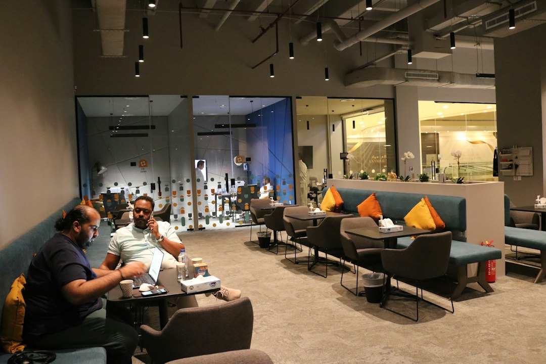 Marketing specialists discussing social media strategy on paper reports in a creative Riyadh office
