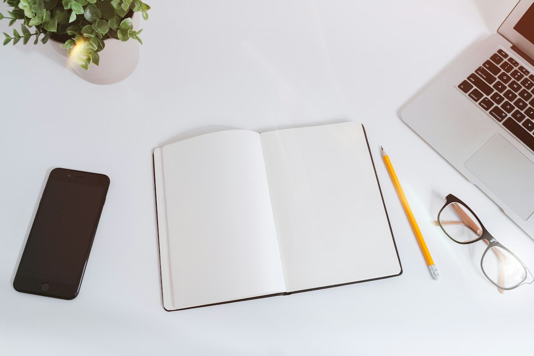 مكتب عمل منظم يتضمن دفتراً لجدولة خطة محتوى سوشيال ميديا شهرية مع كوب قهوة في إضاءة هادئة